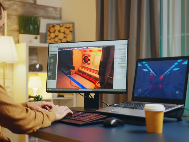 Male game developer typing on keyboard