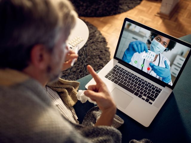 Close-up of man having video call with his doctor in the evening