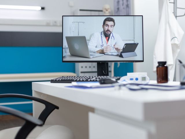 Computer screen with remote doctor having online videocall meeting