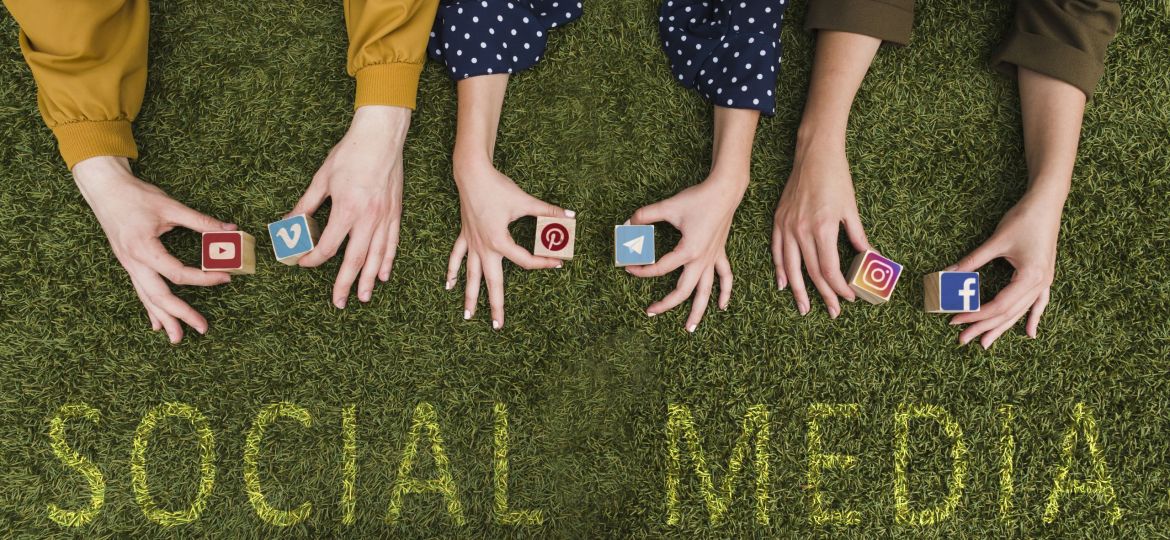 overhead-view-female-s-hand-holding-social-network-app-symbol-blocks-lawn