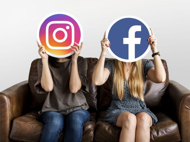 Interracial women holding an expressive emoticon face surprised
